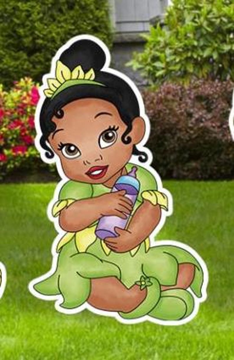 May include: A cartoon illustration of a baby with dark skin and black hair styled in a bun, wearing a green dress with yellow petal accents and a matching headband. The baby is holding a purple baby bottle with a light blue cap.