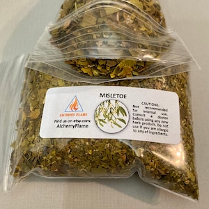 May include: A clear plastic bag filled with dried green mistletoe leaves. The bag has a white label with the text "MISLETOE" and "ALCHEMY FLAME" with a small flame logo. The label also includes a small image of mistletoe berries and leaves. The label includes the text "CAUTIONS: Not recommended for internal use. Consult a doctor before using any new herb product. Do not use if you are allergic to any of ingredients."