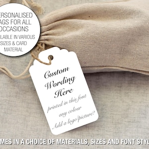 May include: A white tag with scalloped edges, featuring the text "Custom Wording Here" in elegant script, with additional text about font, colour, and logo options. The tag is attached to a drawstring bag. Text on the image reads: "PERSONALISED TAGS FOR ALL OCCASIONS".