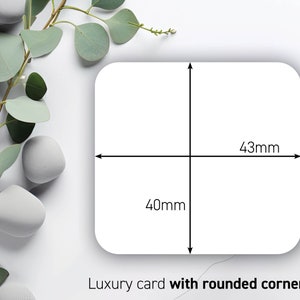 May include: A white luxury card with rounded corners, measuring 43mm by 40mm. The card's dimensions are indicated by black lines and measurements. The card is set against a backdrop of green leaves and white stones.