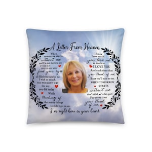 May include: A blue and white cushion with a floral border and a photo of a woman. The cushion has a message that reads "A Letter From Heaven" and includes a poem about missing someone who has passed away.