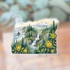 May include: Watercolor sticker in the shape of Oregon, featuring a scenic landscape. The design includes a waterfall, evergreen trees, yellow flowers, a snow-capped mountain, and the Pacific coastline. The sticker has a clear border.