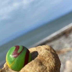 Perfectly frosted Vintage clay green yellow and red  colored Shooter Sea Glass marble found on the beaches of Nova Scotia, Canada.