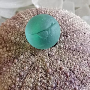 Antique Nova Scotia Sea glass marble with hand-blown pontil mark these were made around the 1920s very rare seaglass find, green cats eye