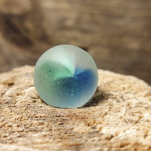 Grüner, blauer und weißer Katzenaugen-Meeresauge-Meeresauge-Meeresglas-Marmor, perfekt gewittert durch das Meer