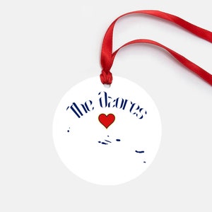 May include: White round ornament with a red heart and the text "The Azores" in blue lettering. The outline of the Azores islands is shown in blue.