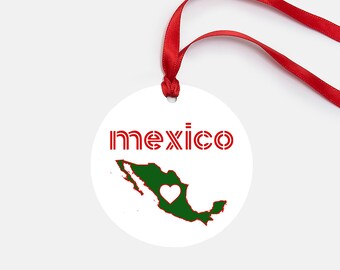 May include: A white round bauble with a red ribbon. The bauble features a green outline of Mexico with a white heart inside. The word "mexico" is written in red letters above the map.