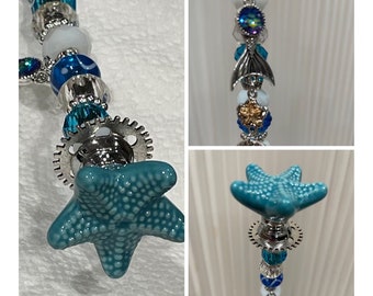 SPECTACULAR Ocean Beaded Garden Stake. This custom design has your choice of topper highlighted by a mermaid’s tail and 2 ocean theme charms