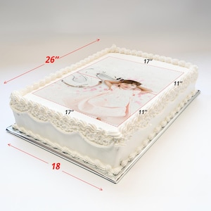 May include: A white cake with a printed image of a girl in a white dress. The cake is 17 inches by 17 inches and is on a 18 inch by 26 inch cake board.