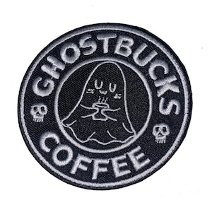 Peut inclure: &Eacute;cusson brod&eacute; noir et blanc avec le texte "GHOSTBUCKS COFFEE" dans un cercle. Il pr&eacute;sente un fant&ocirc;me de dessin anim&eacute; tenant une tasse, avec des ic&ocirc;nes de cr&acirc;ne de chaque c&ocirc;t&eacute;.