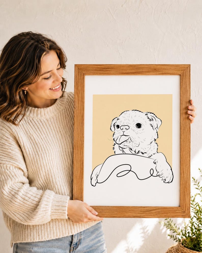 Puede incluir: Una l&aacute;mina art&iacute;stica enmarcada que presenta un dibujo de l&iacute;neas negras de un perro peque&ntilde;o con la lengua fuera, sobre un fondo amarillo claro s&oacute;lido. La ilustraci&oacute;n est&aacute; dentro de un marco rectangular de madera con acabado de veta natural.