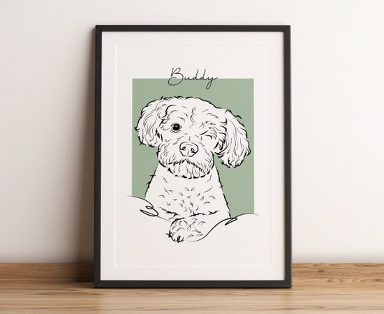 A custom digital print of a white dog winking featuring the name “Buddy” written in a cursive font on the top shown in a black frame.