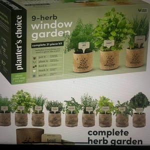 Puede incluir: Un kit completo de jardín de ventana de 9 hierbas con 31 piezas. El kit incluye nueve pequeñas macetas envueltas en arpillera, cada una con una planta de hierba diferente. La caja dice "planter's choice" y "complete herb garden". Cada planta tiene una pequeña etiqueta con su nombre.