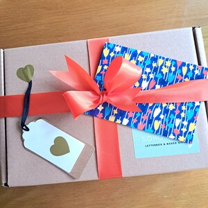 Finished box with ribbon tied in a bow, gift tag and personalised greetings card of choice