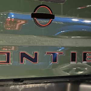 Calcomanía premium de dos colores para la puerta trasera de la Nissan Frontier 2022-2025 con reemplazo gratuito de por vida. ¡Las calcomanías vienen preensambladas con material de transferencia! :)