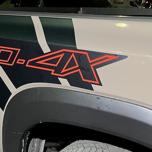 Puede incluir: Primer plano de una caja de cami&oacute;n con un dise&ntilde;o gr&aacute;fico en blanco y negro y el texto "PRO.4X" en rojo.