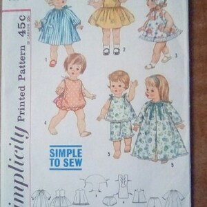 May include: A vintage Simplicity sewing pattern for a 15-inch doll. The pattern includes five different outfits: a blue and white striped dress, a yellow dress, a floral print dress, a floral print pajamas set, and a floral print robe. The pattern is labeled "Simplicity Printed Pattern 45c" and "Simple to Sew".