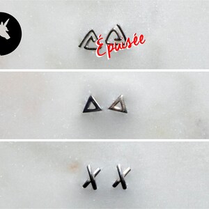 May include: A selection of silver stud earrings in geometric designs. The top row shows open triangles, the middle row has solid triangles, and the bottom row features X-shaped studs. The word "Épuisée" is written in red.