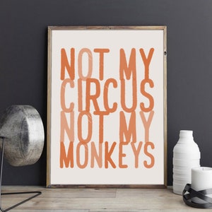 May include: A framed print with the text "NOT MY CIRCUS NOT MY MONKEYS" in orange and peach colors on a white background.