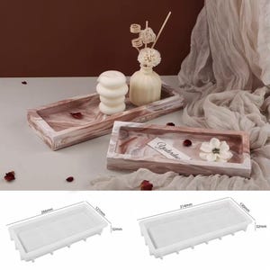 May include: Two rectangular decorative trays with a marbled design in shades of brown and white. One tray holds a white candle and a small vase with decorative stems. The other tray has a white flower and a tag that says "Yesterday".