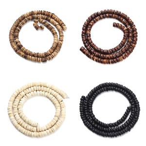 May include: Four strands of wooden beads in different colours: natural, brown, white and black. Each strand is coiled into a circle.