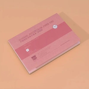 May include: A pink watercolor paper pad with the text "ACADEMY WATERCOLOR PAPER PAD" and "中国宝虹全棉水彩本/学院级" in Chinese. The pad is 180 x 125 mm (7 x 4.9 inches) and has a 300 gsm weight. The paper is fine-grained and is ideal for watercolor painting.