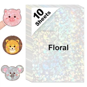 May include: A stack of ten sheets of holographic floral paper with a corner label. Three animal-shaped stickers are visible: a pink pig, a lion, and a koala.