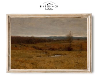 Puede incluir: Una impresión enmarcada de un paisaje con un campo de hierba dorada y una pequeña masa de agua bajo un cielo nublado. La obra de arte tiene una estética vintage, con una paleta de colores apagados de marrones, verdes y grises. El marco es de color claro y neutro. El texto "GINGER AND CO. Print Shop" está en la parte superior.