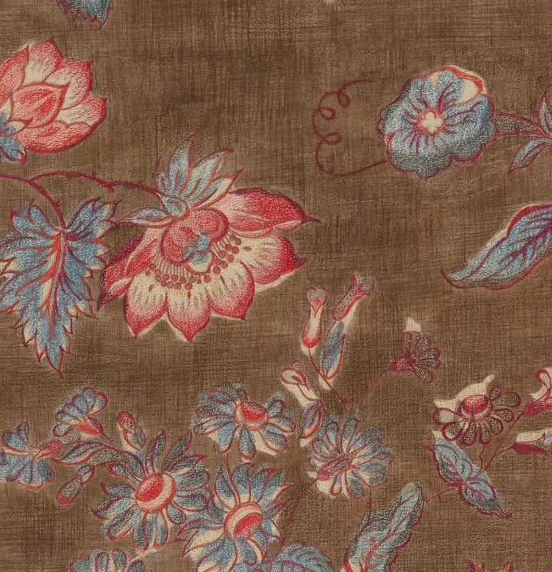 May include: A brown fabric with a floral pattern. The flowers are in shades of pink, red, blue, and white. The fabric has a textured surface.