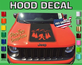 May include: A red Jeep with a black hood decal featuring a Bigfoot silhouette in a forest setting. The decal also includes the text "ProTec Graphics" and "Jeep".