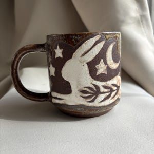 May include: A rustic wooden sign with the text "Welcome to our home" in white lettering. The sign features a distressed finish and a simple, inviting design, perfect for entryway decor.