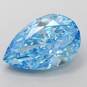 May include: A pear-shaped blue gemstone with a faceted cut. The gemstone is clear and has a light blue color.
