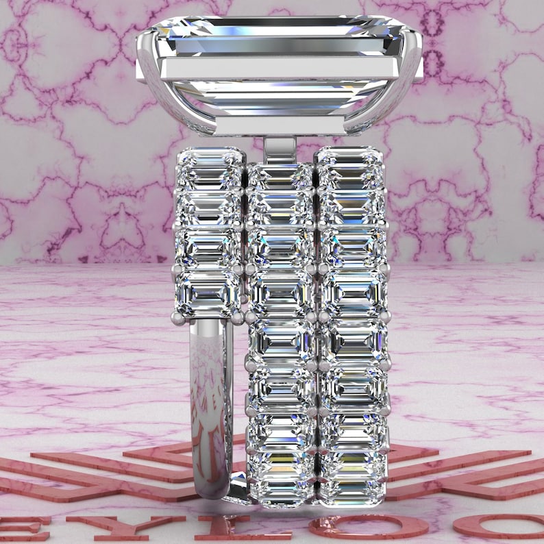 May include: A silver ring with three bands of emerald-cut diamonds. The top band features a larger emerald-cut diamond.