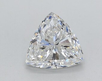 Può includere: Un diamante a taglio brillante di forma triangolare. La gemma è trasparente e incolore, con numerose sfaccettature che riflettono la luce. Il diamante ha la forma di un triangolo equilatero.