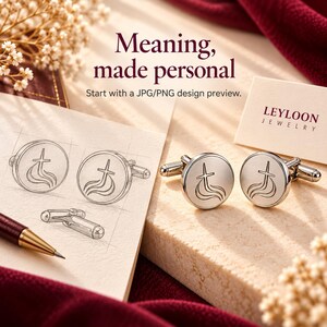 May include: A pair of round silver-toned metal cufflinks featuring an engraved cross and flame design. Next to the cufflinks is a sketch of the same design on paper, a maroon pen, and a card labeled Leyloon Jewelry with the text Meaning, made personal.