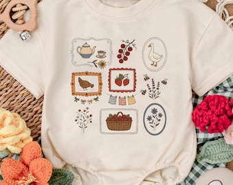 May include: Cream-colored baby onesie with a collection of illustrated farm-themed images. The illustrations include a teapot, goose, strawberries, a chicken, and a basket of berries. The onesie has short sleeves and snap closures.