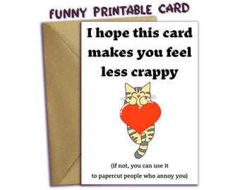 Könnte beinhalten: Eine weiße Grußkarte mit braunem Umschlag, die eine getigerte Katze mit einem großen roten Herzen zeigt. Der Text lautet: I hope this card makes you feel less crappy (if not, you can use it to papercut people who annoy you).
