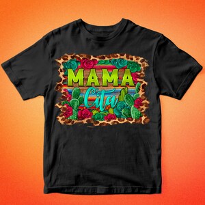 May include: Black t-shirt with a colorful graphic design. The design features the word "MAMA" in green, the word "Cita" in turquoise, and images of cacti, roses, and a leopard print border. The text "BARKALOO DESIGN" is at the top and bottom.