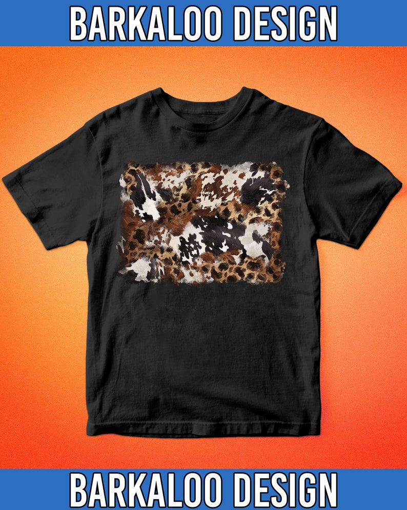 May include: Black t-shirt featuring a rectangular cowhide pattern in shades of brown, white, and black. The shirt has short sleeves and a crew neck. The text "BARKALOO DESIGN" is printed in white at the top and bottom of the image.