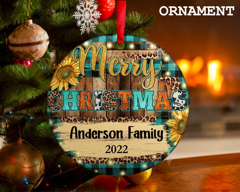 Pu&ograve; includere: Un addobbo natalizio rotondo con uno sfondo in legno rustico, un motivo a quadri blu e neri e un design a stampa leopardata. L'addobbo presenta il testo "Merry Christmas" in lettere dorate glitterate e "Anderson Family 2022" in lettere bianche.