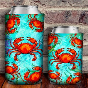 May include: Two insulated beverage holders with a blue and green ocean background and a repeating pattern of orange crabs.