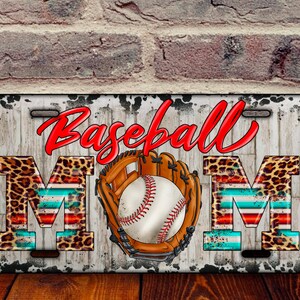 K&ouml;nnte beinhalten: Ein wei&szlig;es Nummernschild aus Metall mit einem abgenutzten Look. Die Worte "Baseball Mom" sind in roten und schwarzen Buchstaben mit Leopardenmuster und rot-wei&szlig;-blauen Streifen. Ein Baseball und ein Handschuh befinden sich in der Mitte des Nummernschilds.