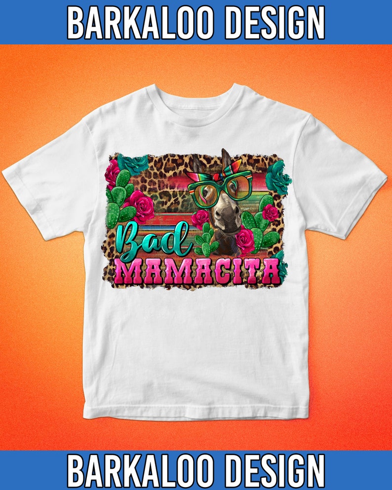 May include: White t-shirt with a graphic of a donkey wearing sunglasses and a bandana. The donkey is surrounded by cacti, flowers, and a leopard print background. The text "Bad Mamacita" is written in pink and turquoise letters.