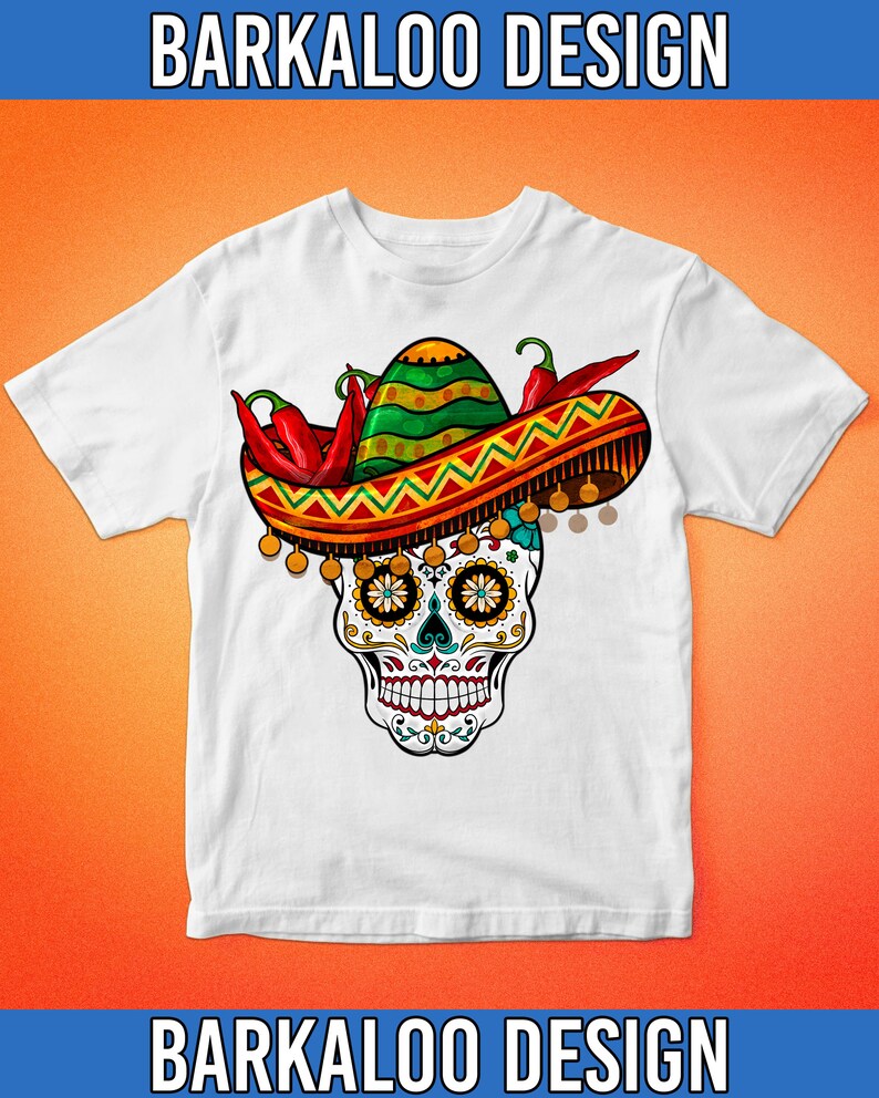 May include: White t-shirt with a colorful sugar skull wearing a sombrero with red chili peppers. The skull has intricate details and is surrounded by a yellow and orange patterned border.