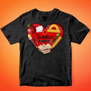 Pode incluir: Camiseta preta com um design de cora&ccedil;&atilde;o vermelho que apresenta v&aacute;rios materiais escolares, incluindo uma ma&ccedil;&atilde;, l&aacute;pis, uma r&eacute;gua e um livro. O cora&ccedil;&atilde;o tamb&eacute;m inclui a palavra "Teacher".