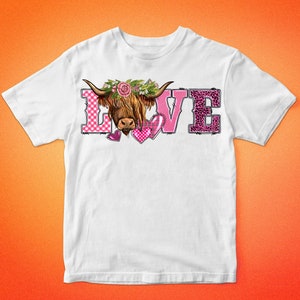 May include: White t-shirt featuring the word "LOVE" with a Highland cow graphic. The "L" is pink gingham, the "O" is the cow's face, the "V" has pink hearts, and the "E" is leopard print. The shirt has the text "BARKALOO DESIGN" at the top and bottom.