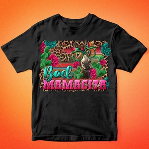 May include: Black t-shirt with a graphic of a donkey wearing sunglasses and a bandana. The donkey is surrounded by cacti and flowers. The text "Bad Mamacita" is written below the donkey.