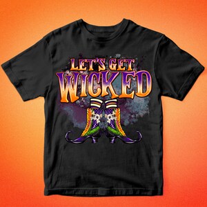 K&ouml;nnte beinhalten: Schwarzes T-Shirt mit einem lila, orange und gr&uuml;nen Design mit dem Text "Let's Get Wicked" und einem Paar Hexenstiefeln.