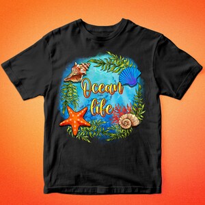 Op de afbeelding: Zwart T-shirt met een kleurrijk ontwerp van zeeleven. Het ontwerp bevat een zeester, schelpen, zeewier en de tekst "Ocean life".