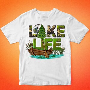 K&ouml;nnte beinhalten: Wei&szlig;es T-Shirt mit einem gr&uuml;nen Tarnmuster, auf dem "LAKE LIFE" steht, mit einem kleinen Baum und einem Boot mit Rudern im Wasser.